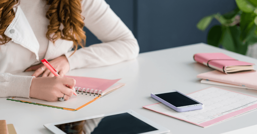 woman writing on a notepad
